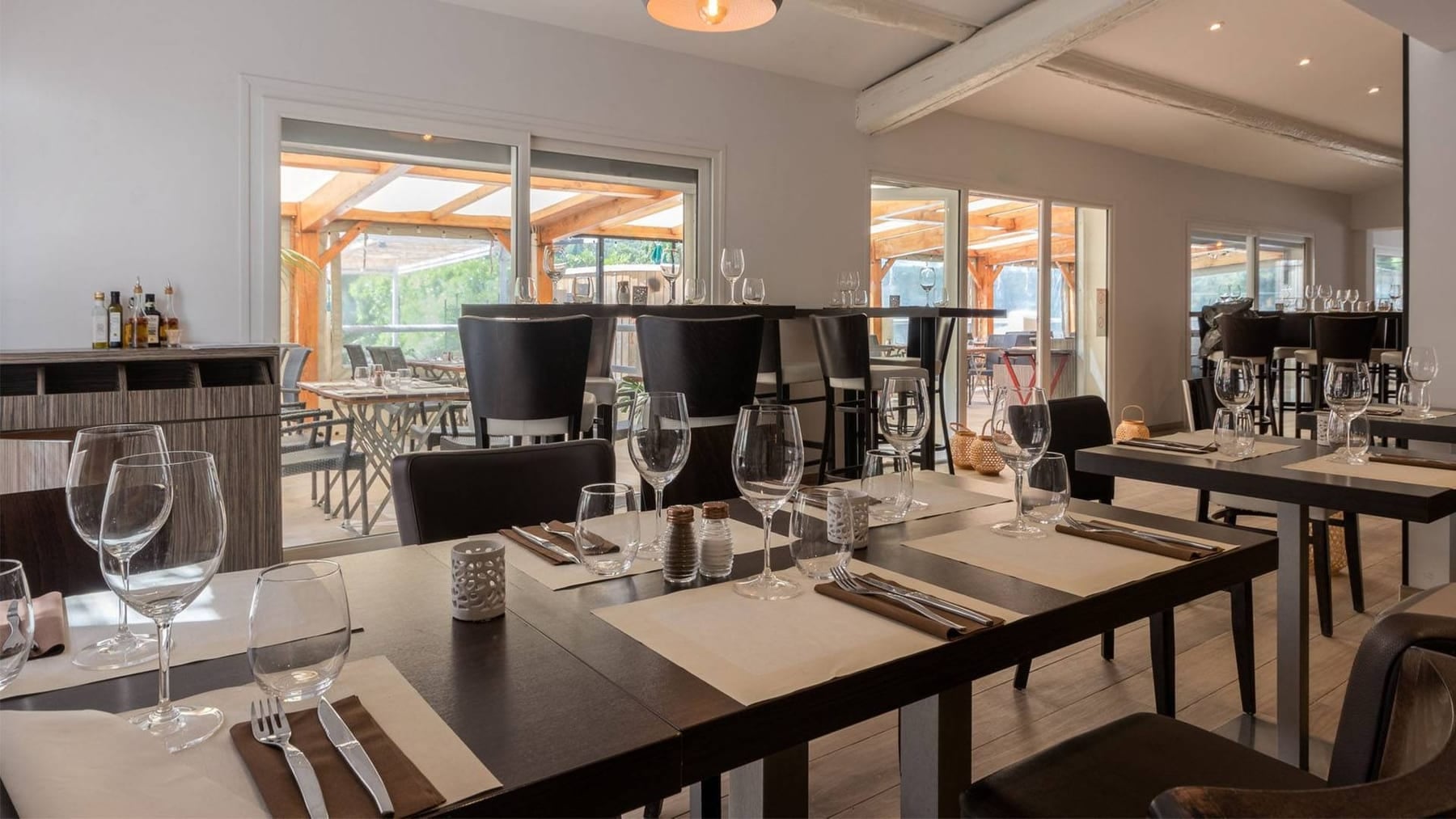 Salle de La Paillote, tables dressées devant la baie vitrée